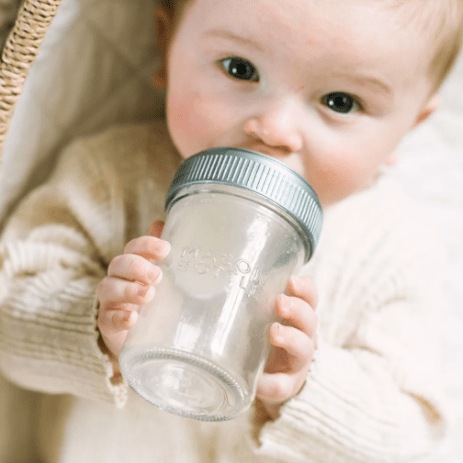 Photo of a baby drinking from an 8oz mason bottle.