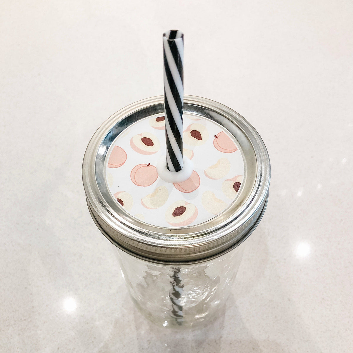 Photo of a mason jar straw lid with a pictures of a peaches