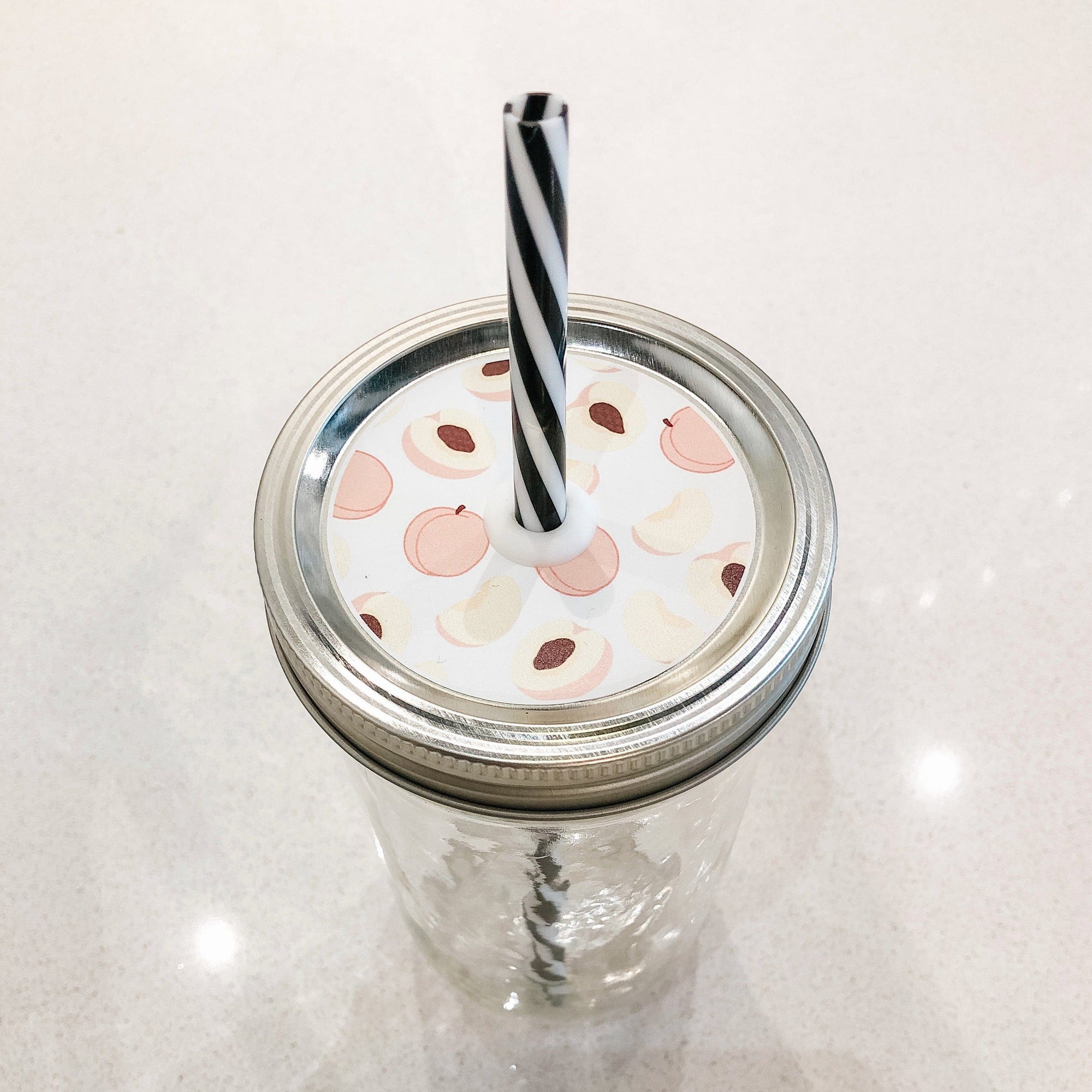 Photo of a mason jar straw lid with a pictures of a peaches