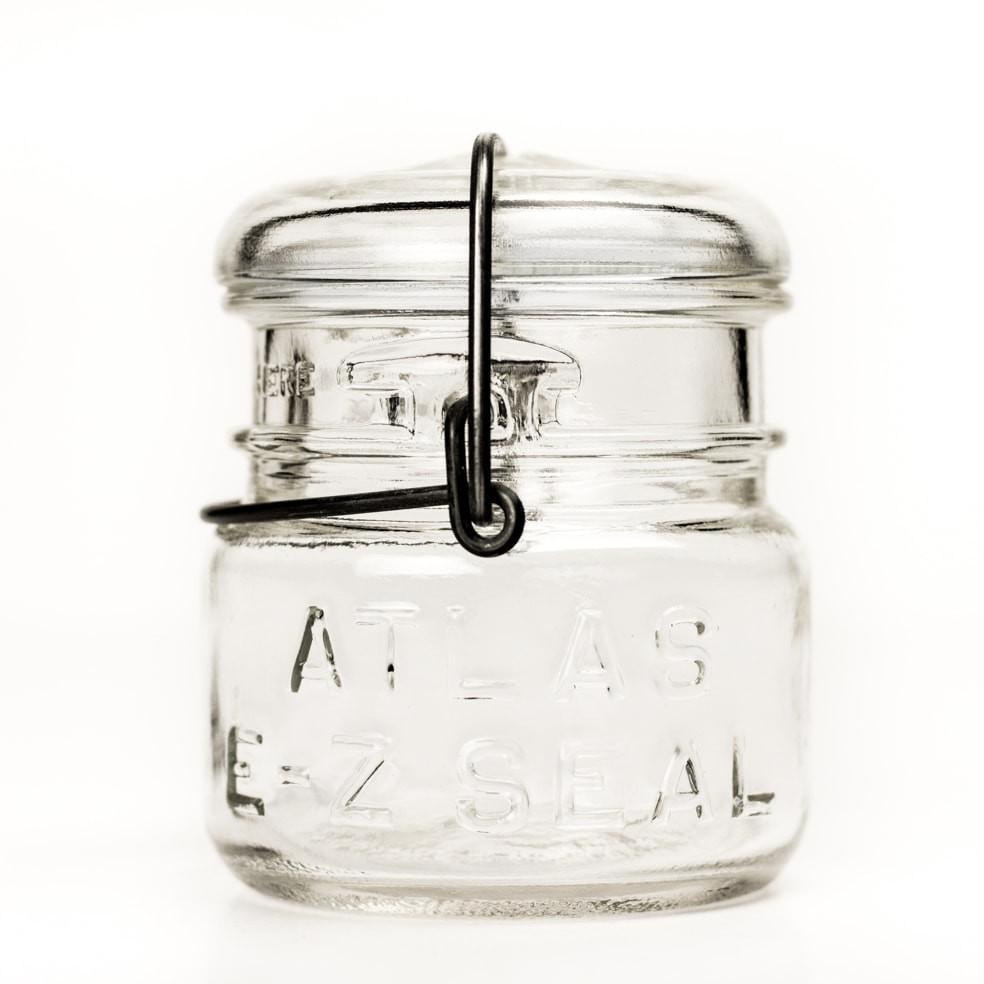 Vintage half-pint Atlas E-Z Seal jar with wire bail and glass lid, against a white background 