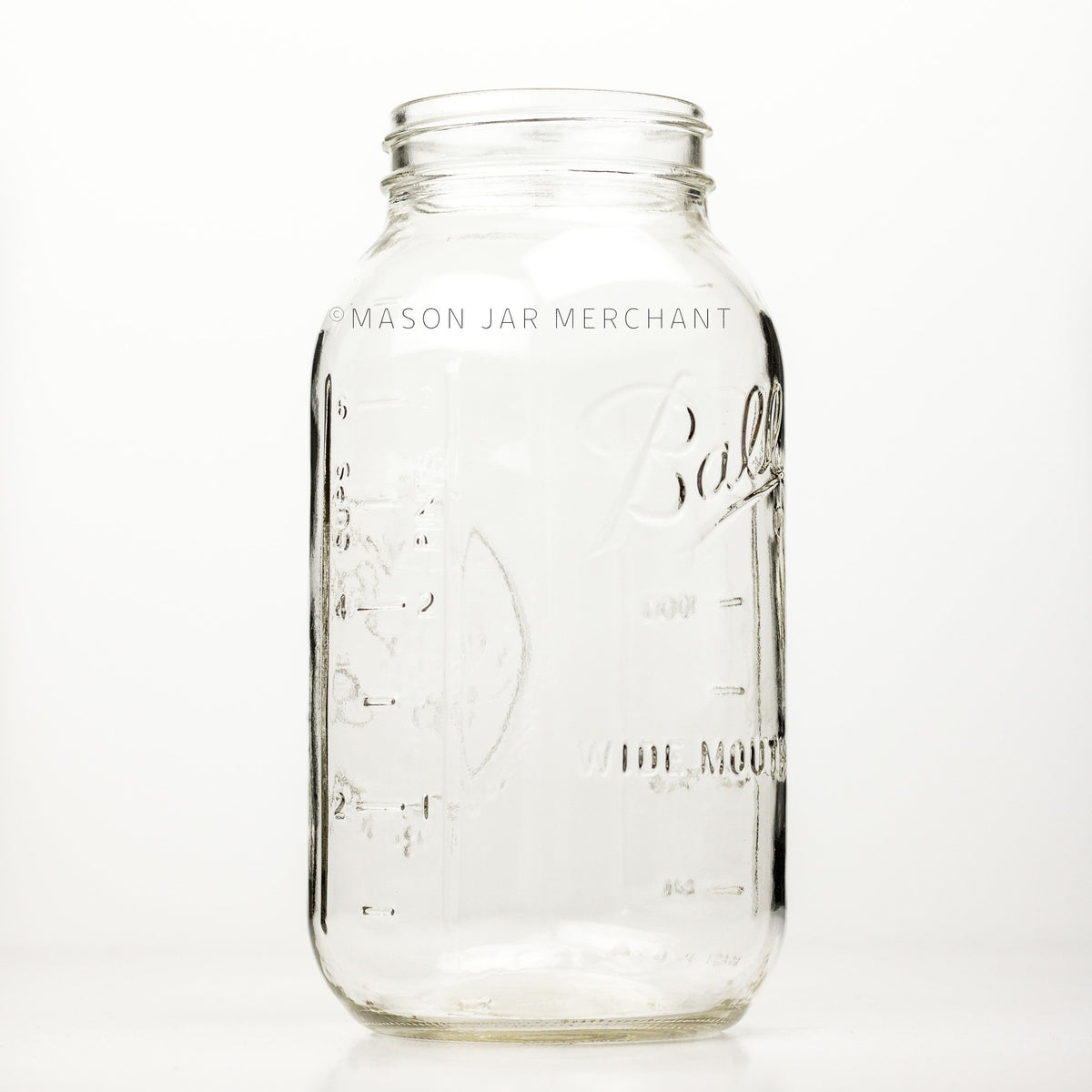 Wide mouth half-gallon mason jar with Ball Wide mouth logo, and fruity oval design visible on the back side of the jar. against a white background. It has a measurement engraved on its back