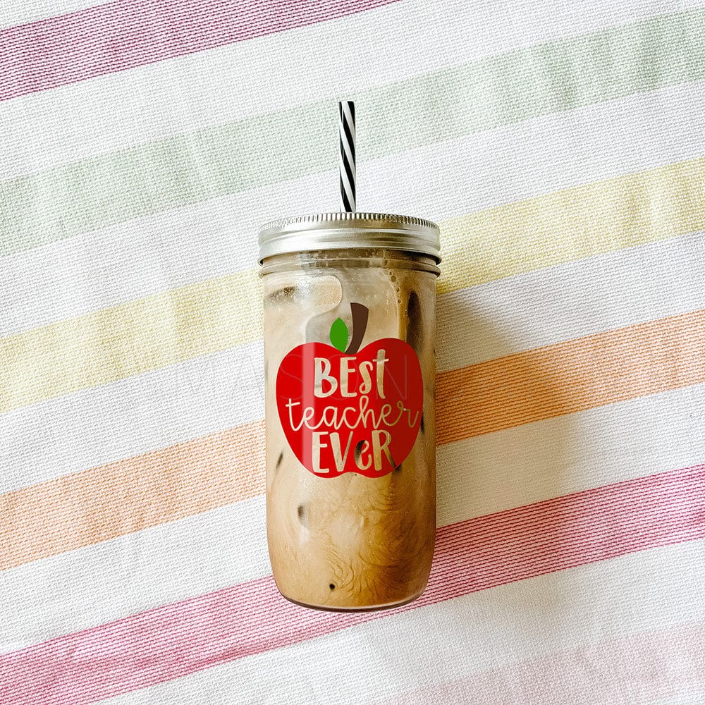 "Best Teacher Ever" print inside a red apple printed on tumbler with iced coffee against a striped picnic fabric.