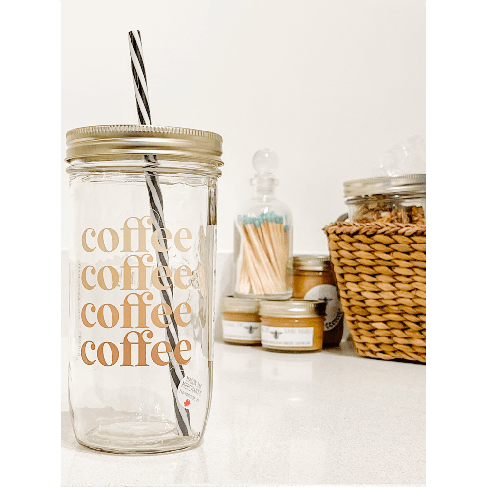 Photo of a mason jar with a gold lid and a black and white spiral straw. Small jars and a basket as a background.