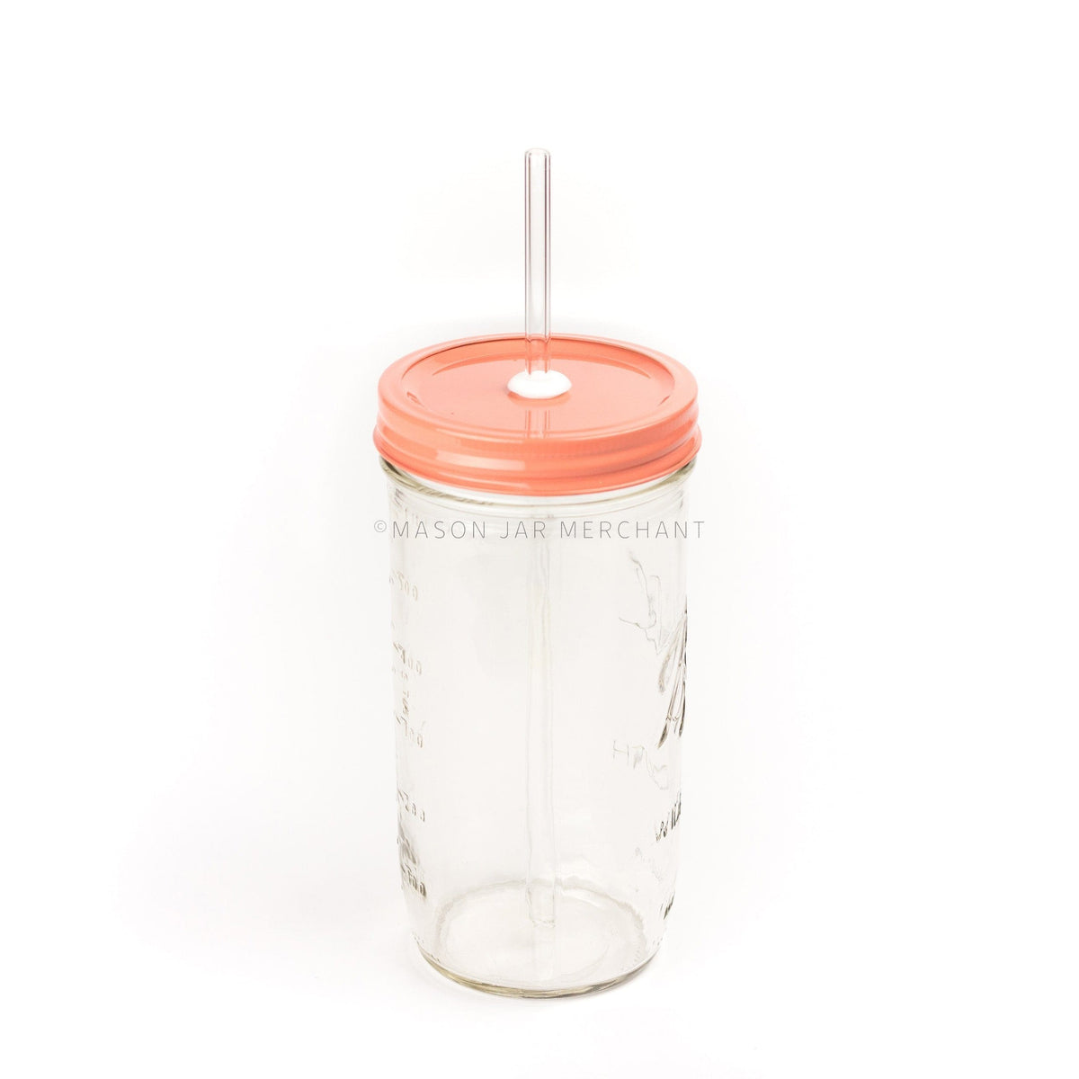 A 24 oz mason jar with a coral coloured painted straw lid and a glass straw against a white background