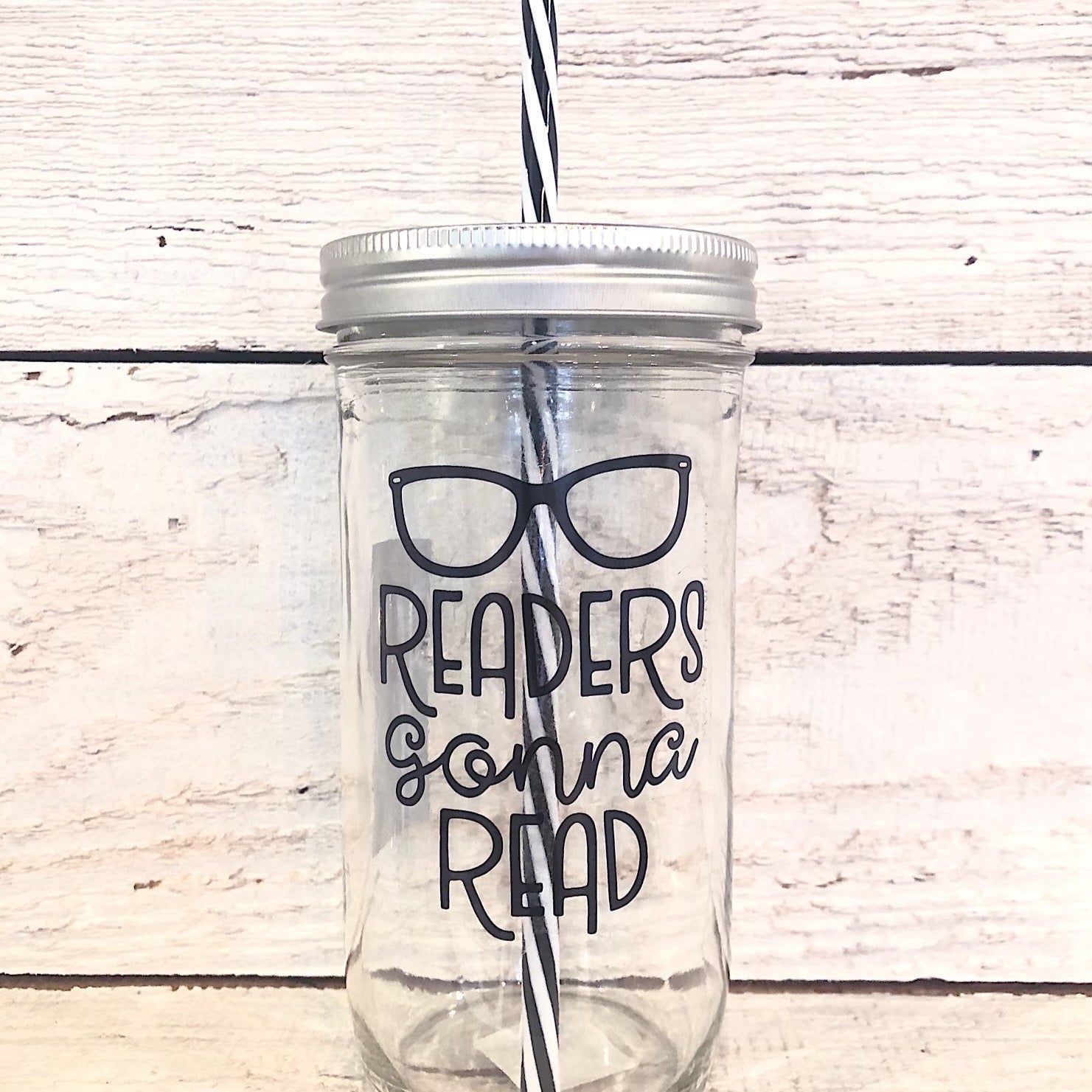 Mason jar tumbler that says “readers gonna read” with a pair of glasses above the text