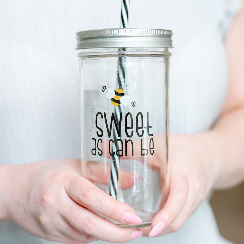 A close up of a Photo of a mason jar tumbler with a print of a bee and a text that says &quot;sweet as can be&quot;.
