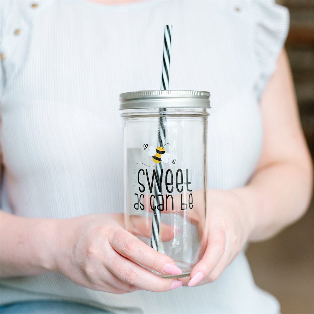 Photo of a mason jar tumbler with a print of a bee and a text that says &quot;sweet as can be&quot;.