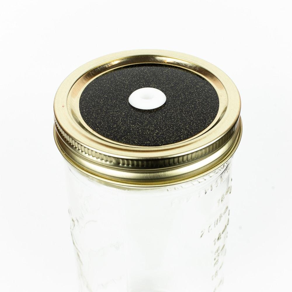 Black with gold Glitter Mason Jar Straw Lid on a golden lid against a white background.