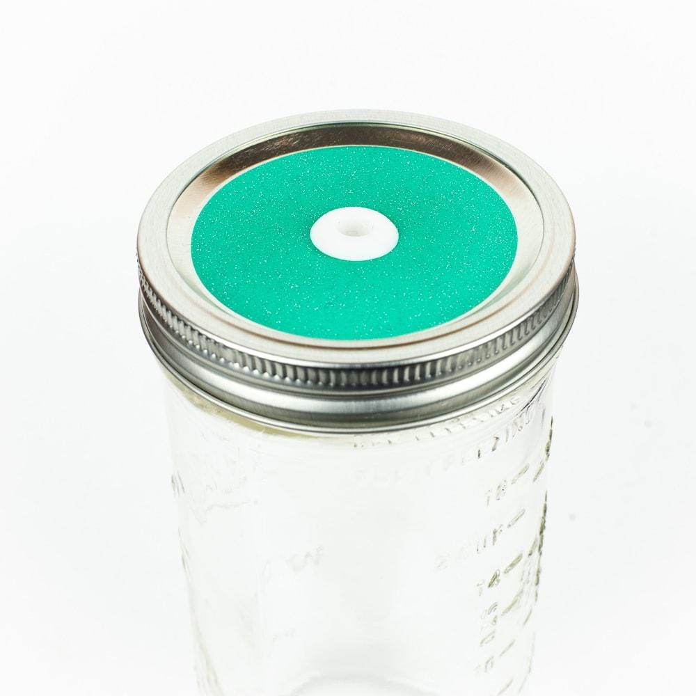 Bright aqua Glitter Mason Jar Straw Lid on a silver lid against a white background.