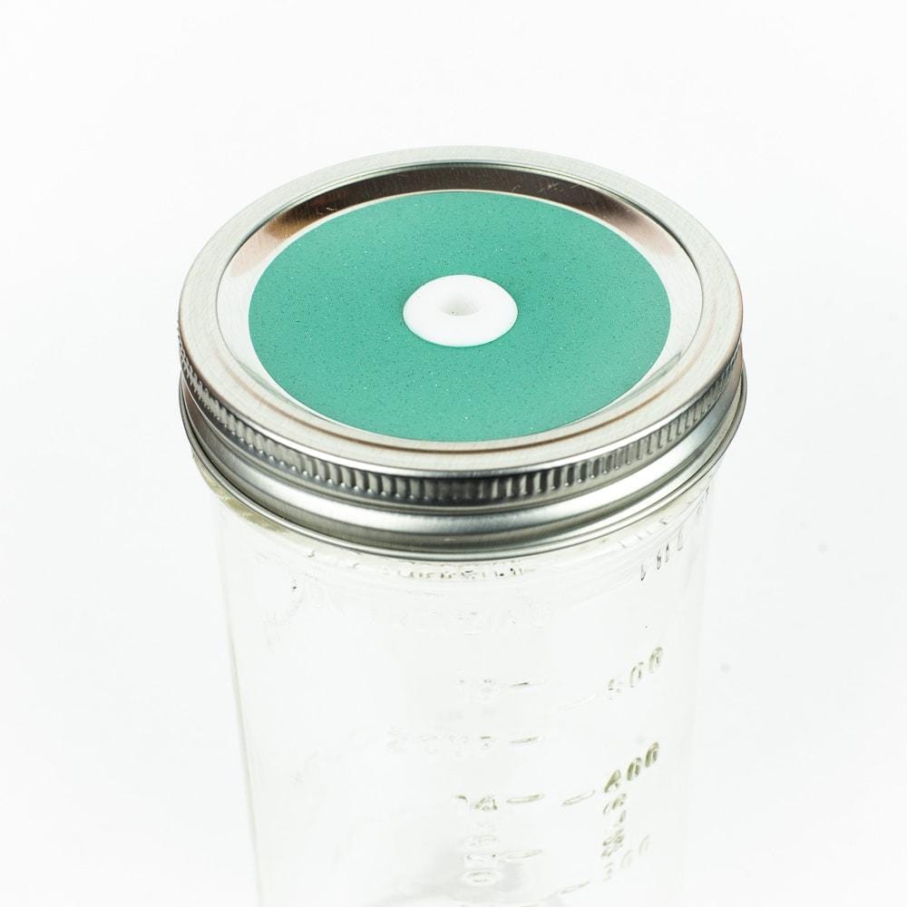 Seafoam blue green  Glitter Mason Jar Straw Lid on a silver lid against a white background.