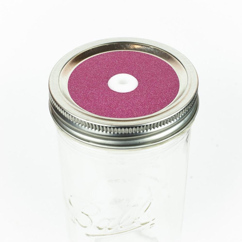 Mauve Glitter Mason Jar Straw Lid on a silver lid against a white background.