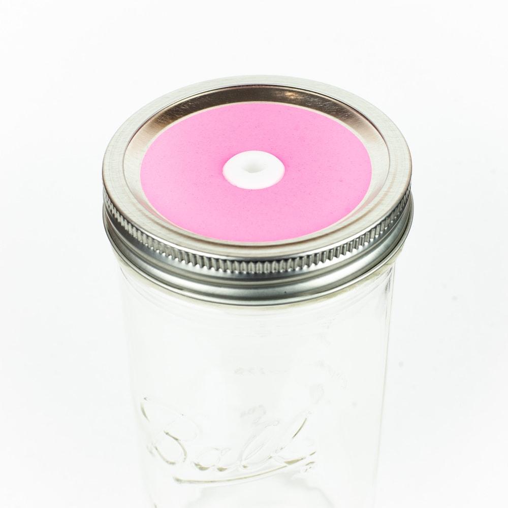 Light pink Glitter Mason Jar Straw Lid on a silver lid against a white background.