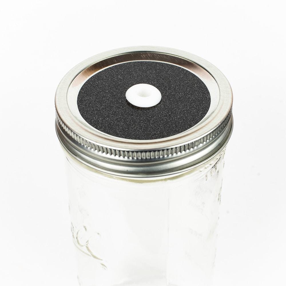 Dark grey Glitter Mason Jar Straw Lid on a silver lid against a white background.