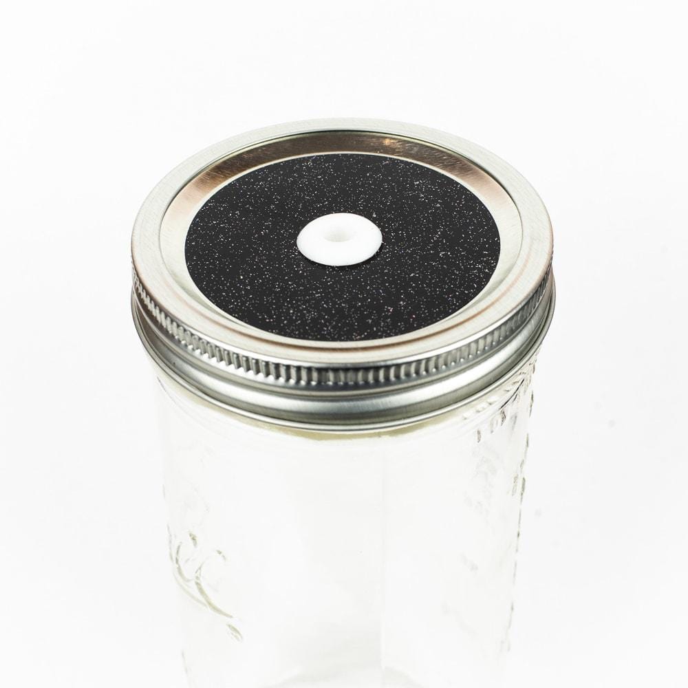 Black with rainbow Glitter Mason Jar Straw Lid on a silver lid against a white background.