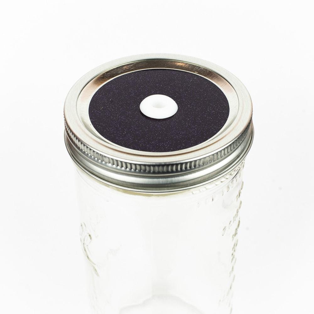 Dark purple Glitter Mason Jar Straw Lid on a silver lid against a white background.