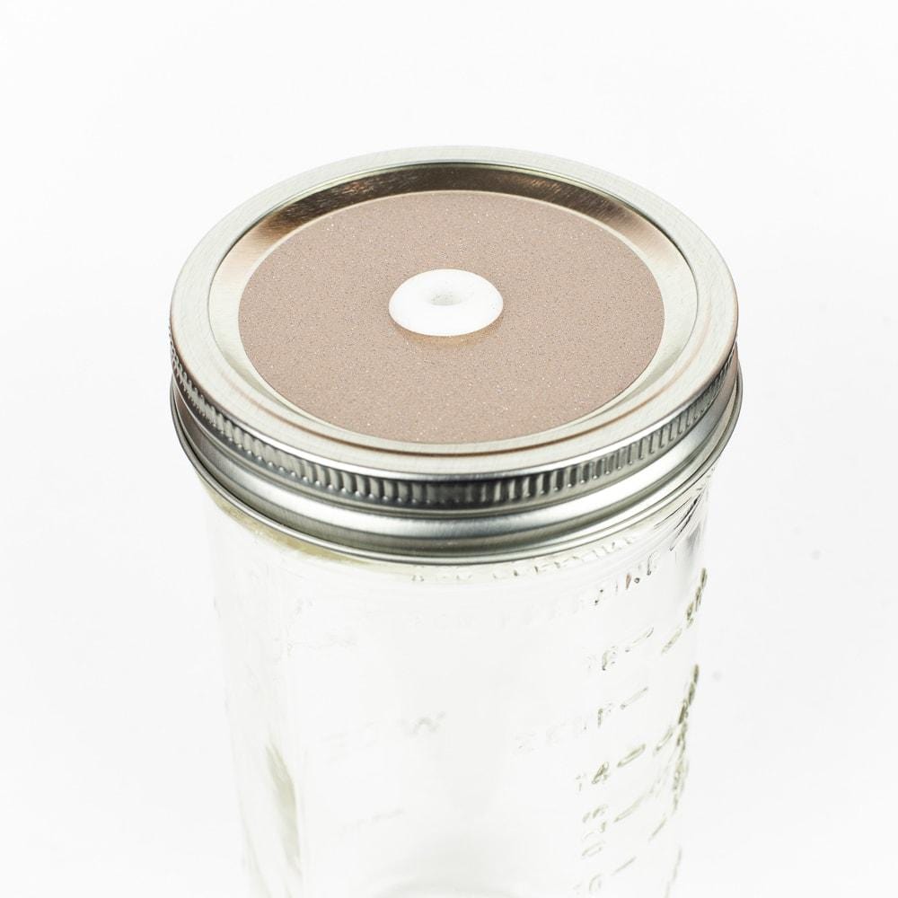 Champagne Glitter Mason Jar Straw Lid on a silver lid against a white background.