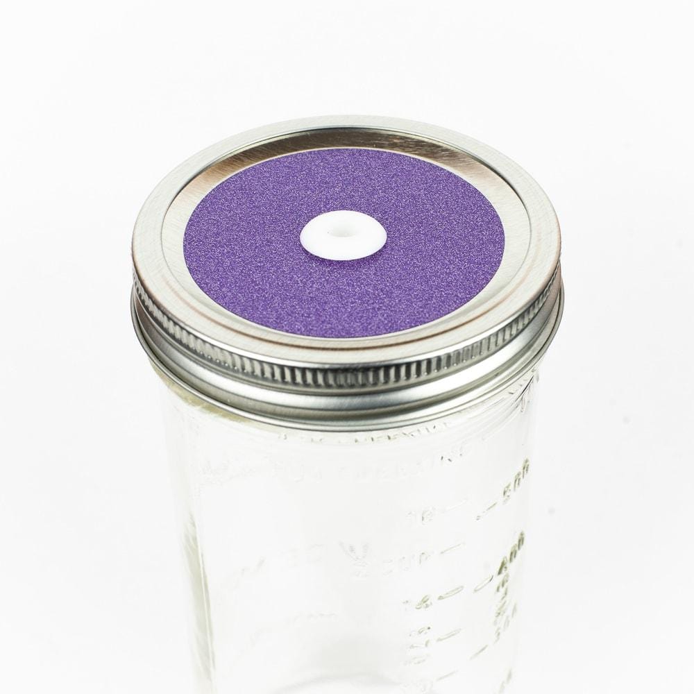 Light purple Glitter Mason Jar Straw Lid on a silver lid against a white background.
