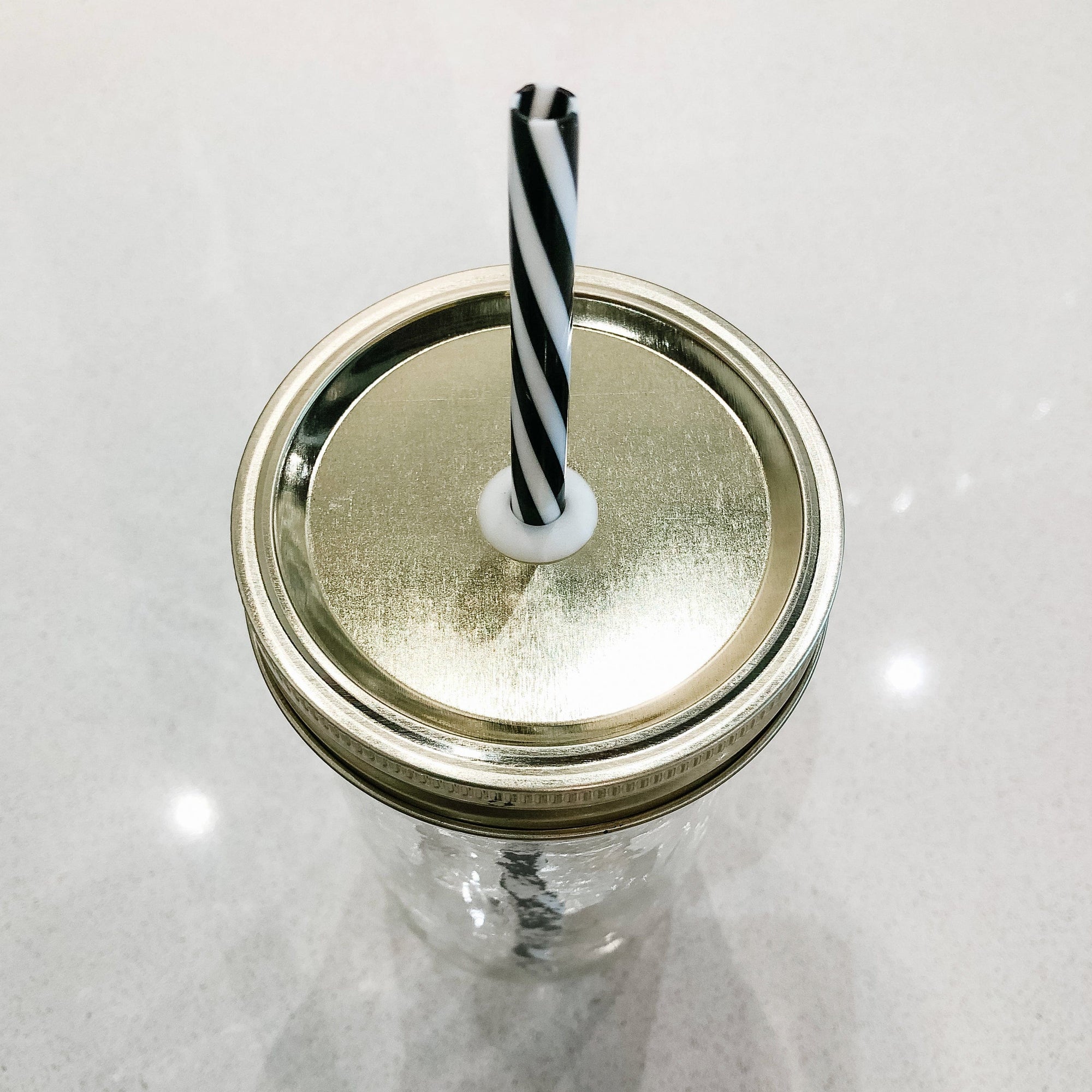 photo of a gold straw lid with black and white straw