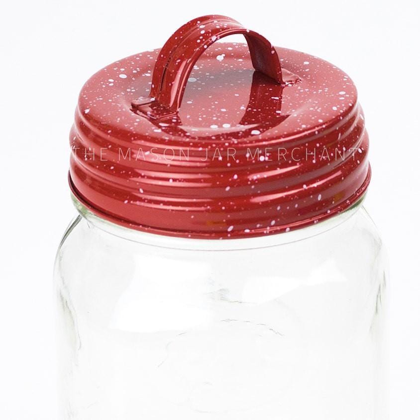 close up of a enamel red speckle mason jar lid with a handle on a white background
