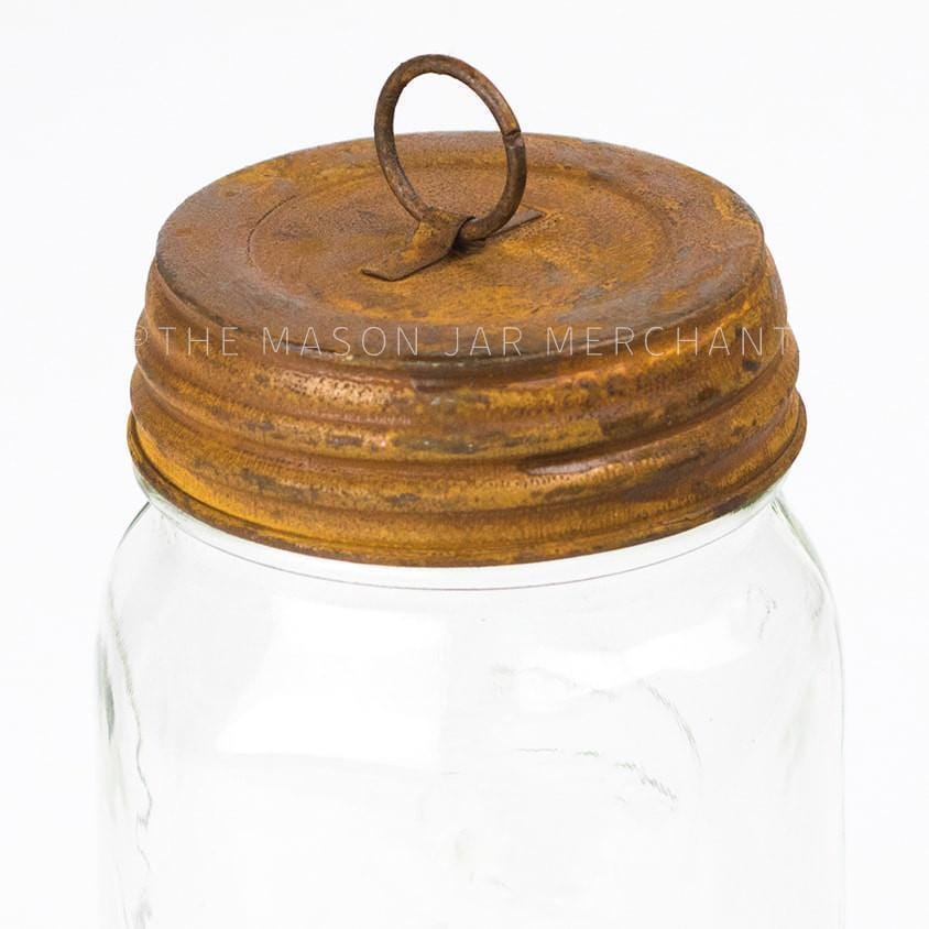 close up of a rusty hanging lid on a glass mason jar on a white background