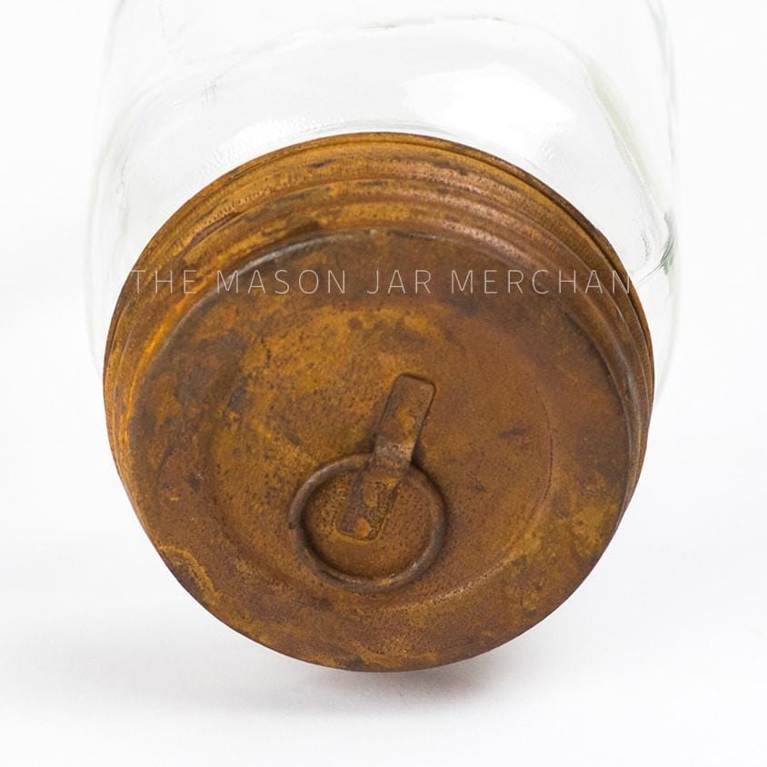 close up of a rusty hanging lid on a glass mason jar on a white background