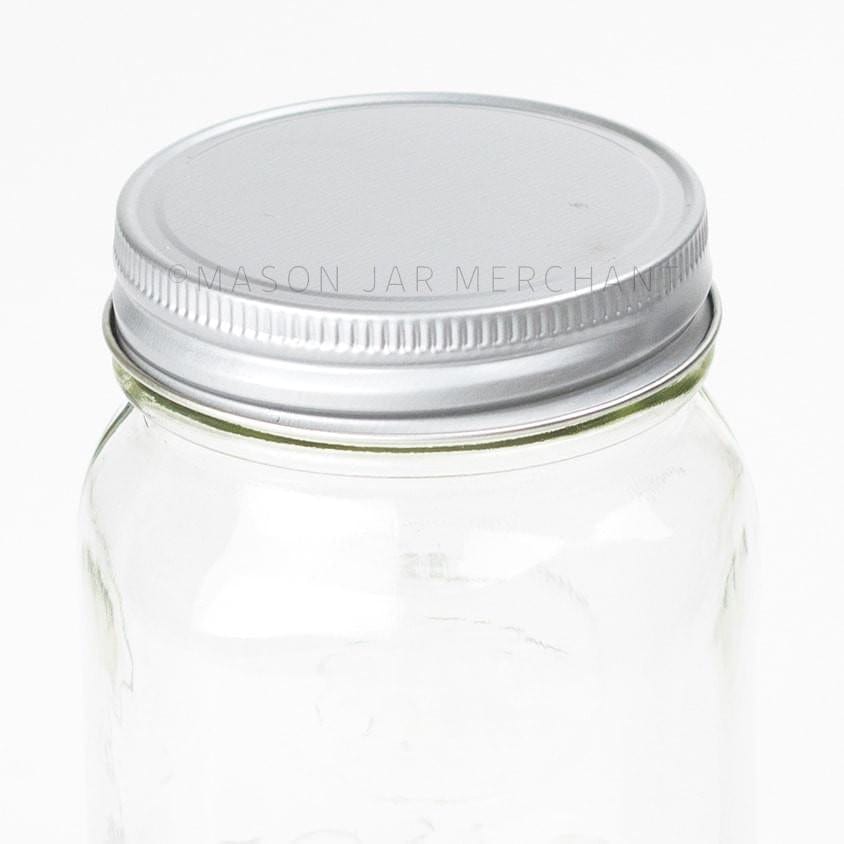 solid white metallic unlined regular mouth lid on a glass mason jar on a white background