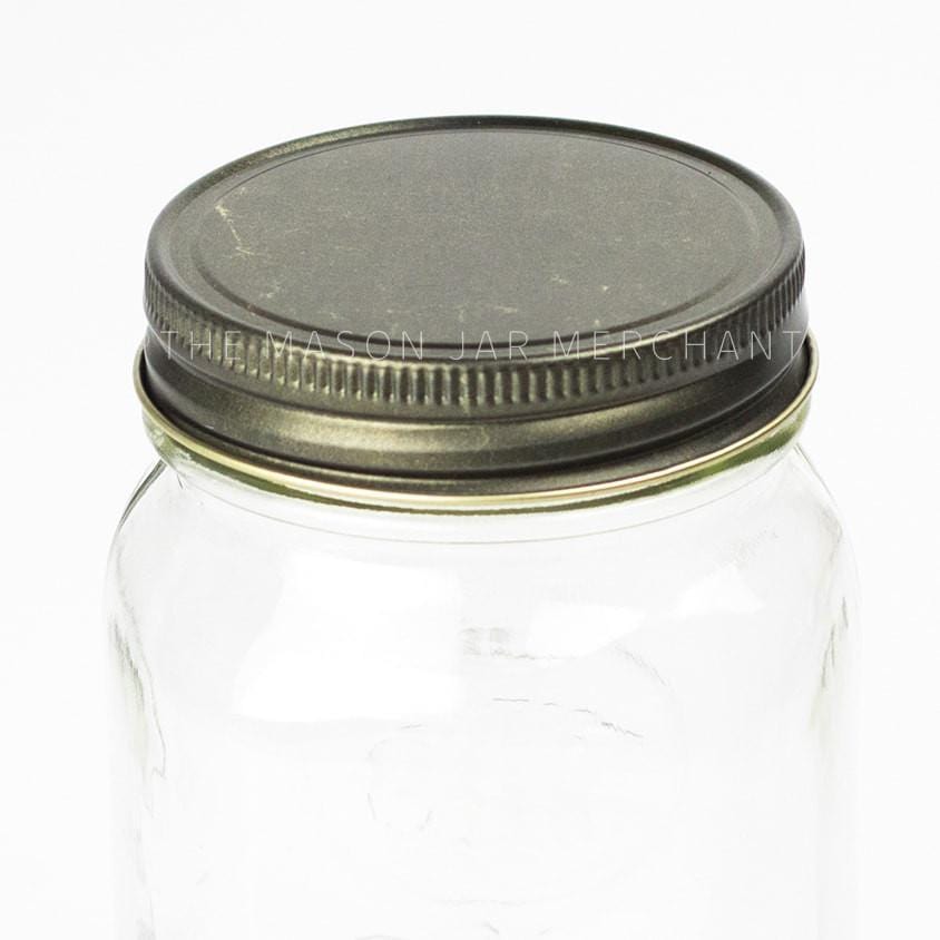 solid gold metallic unlined regular mouth lid on a glass mason jar on a white background