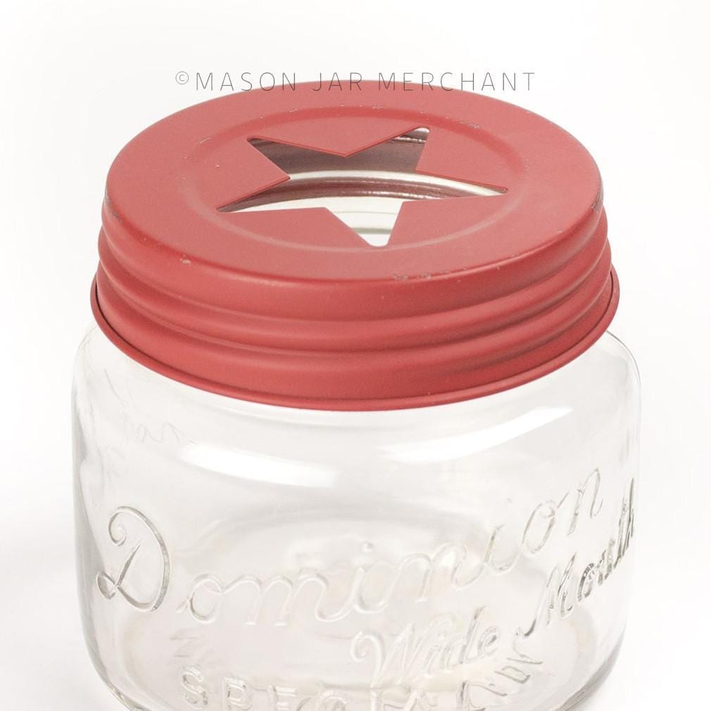 close up of a rustic red star cut out lid on a glass mason jar on a white background