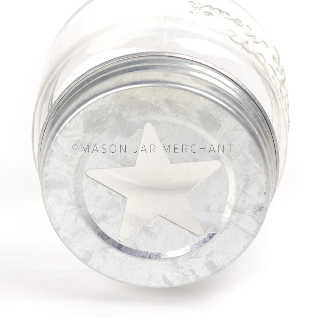 close up of a rustic galvanized star cut out lid on a glass mason jar on a white background