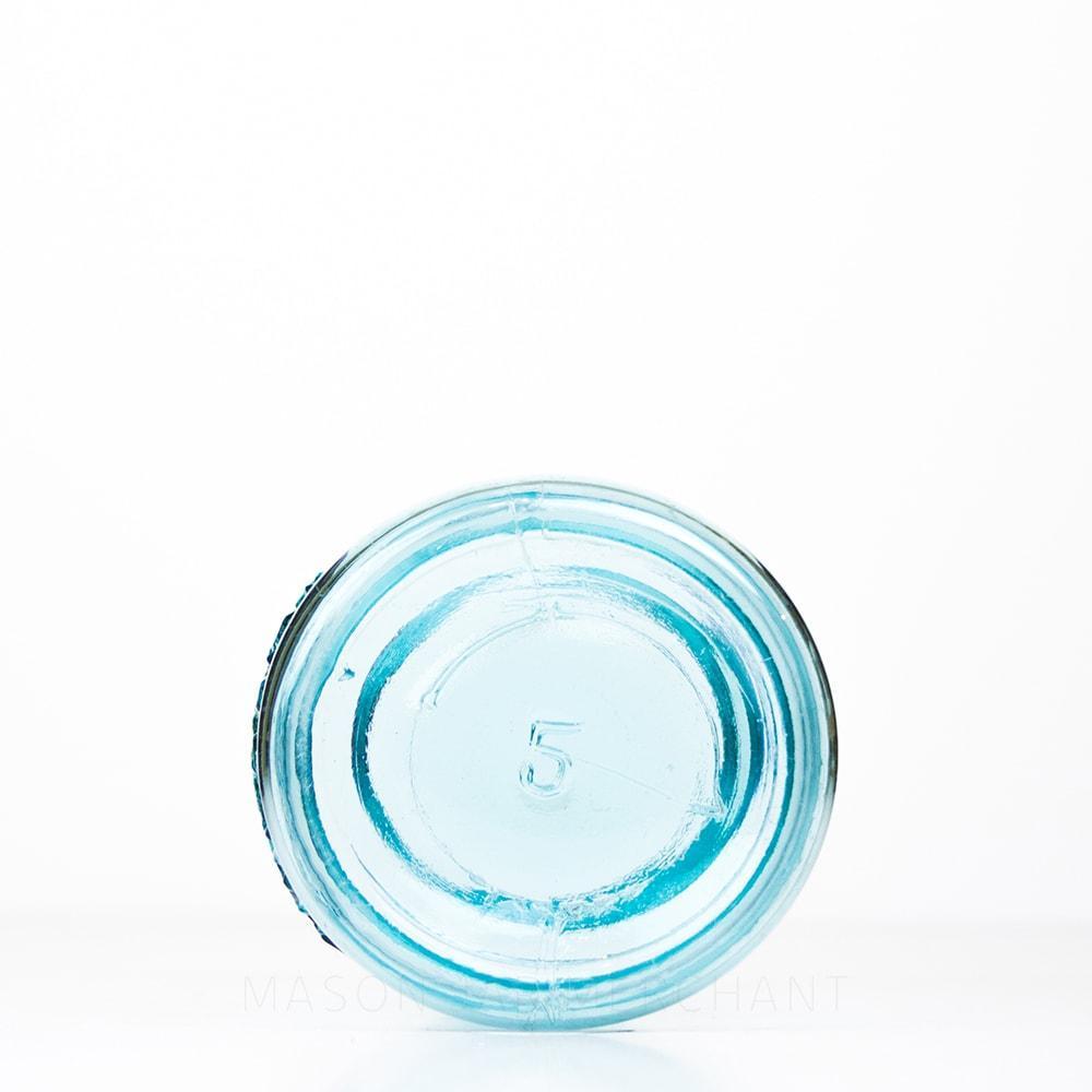 Bottom of a Vintage blue Ball regular mouth quart mason jar against a white background