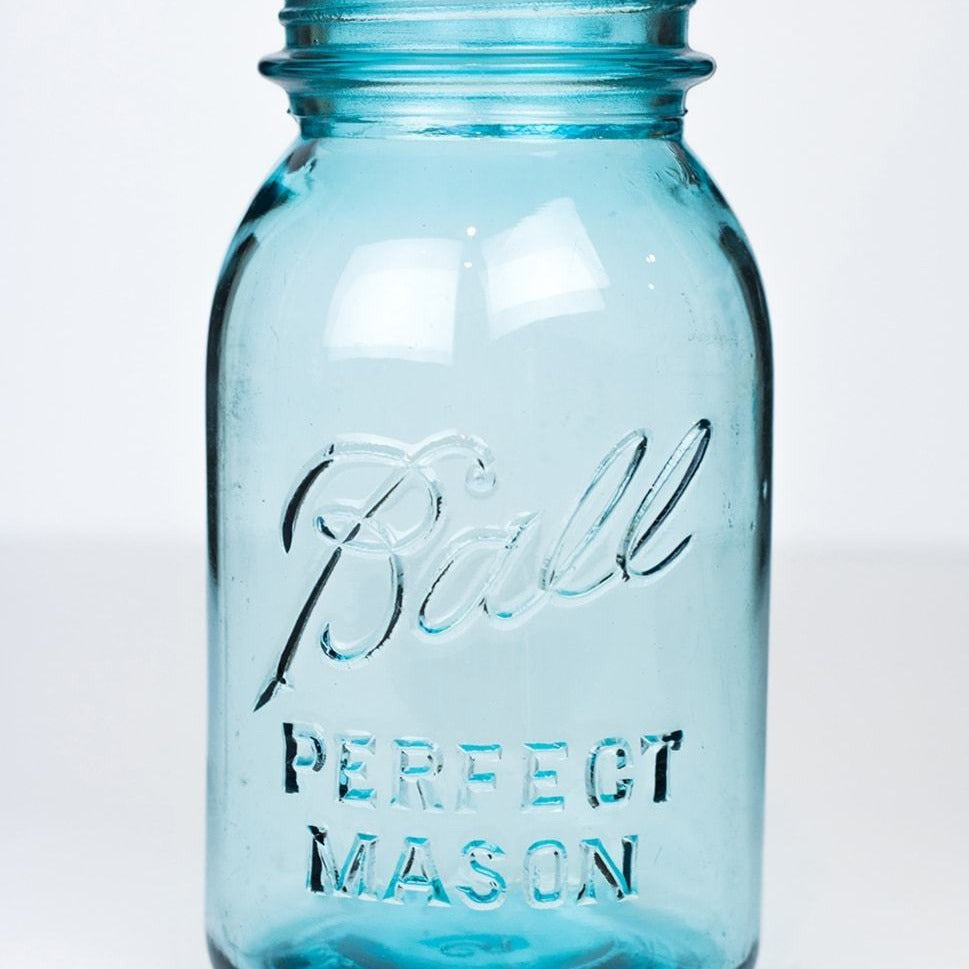 Vintage blue Ball regular mouth quart mason jar against a white background