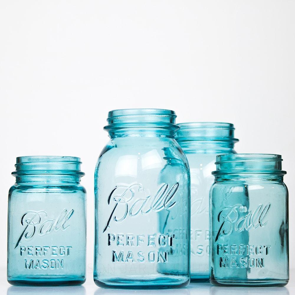 Four Vintage blue Ball regular mouth quart mason jar against a white background