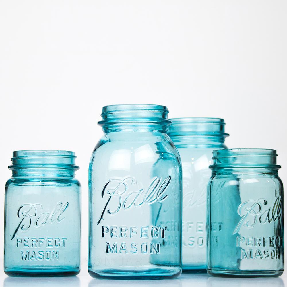 Four Vintage blue regular mouth Ball pint size mason jar against a white background