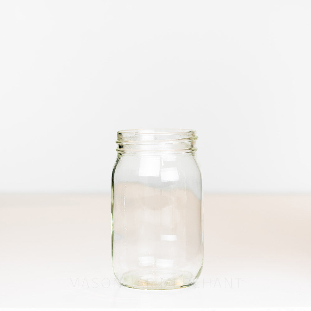 Regular mouth pint mason jar with plain sides, no markings, on a white background 
