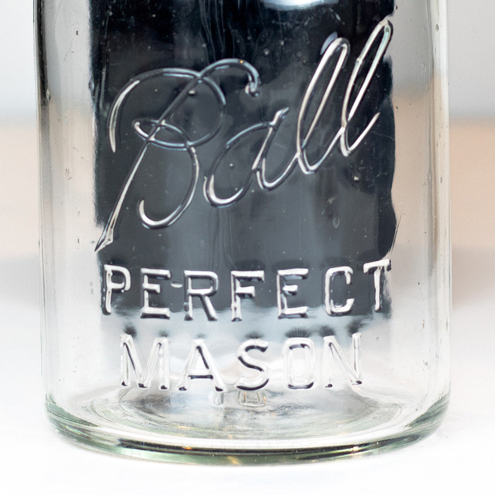 Close-up of the Ball Perfect Mason logo on a vintage quart Ball mason jar