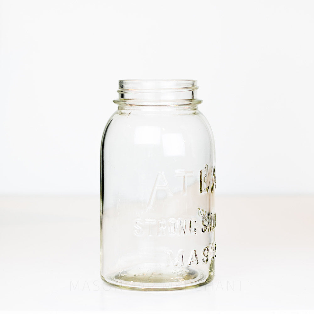 side view of a Vintage Atlas brand regular mouth quart mason jar on a white background