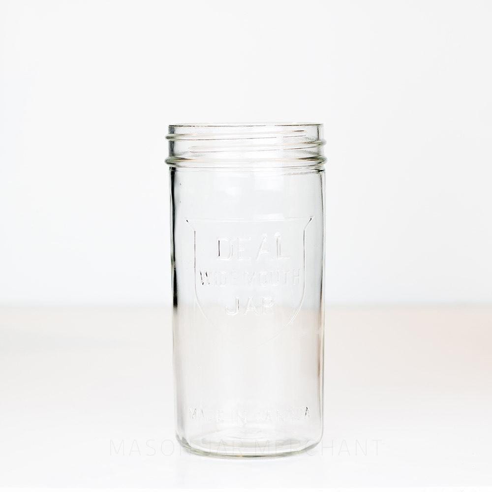 Ideal brand wide mouth 24 oz mason jar with shield logo on front, on a white background