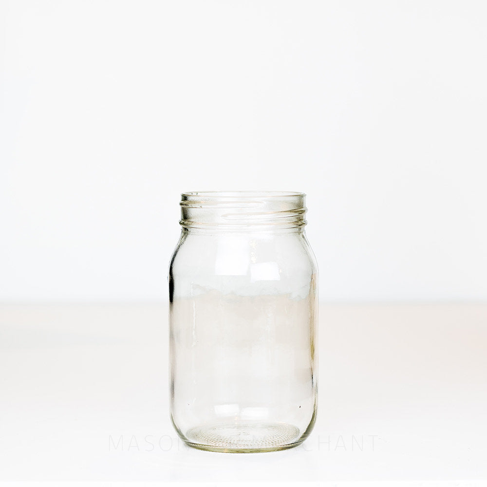 Regular mouth pint mason jar with plain sides on a white background 