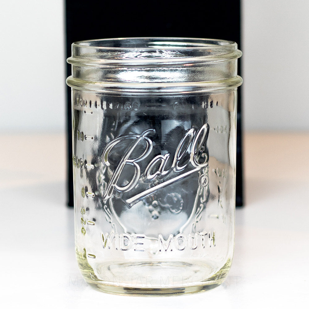 close up of a Ball wide mouth pint mason jar with logo showing, on a white background