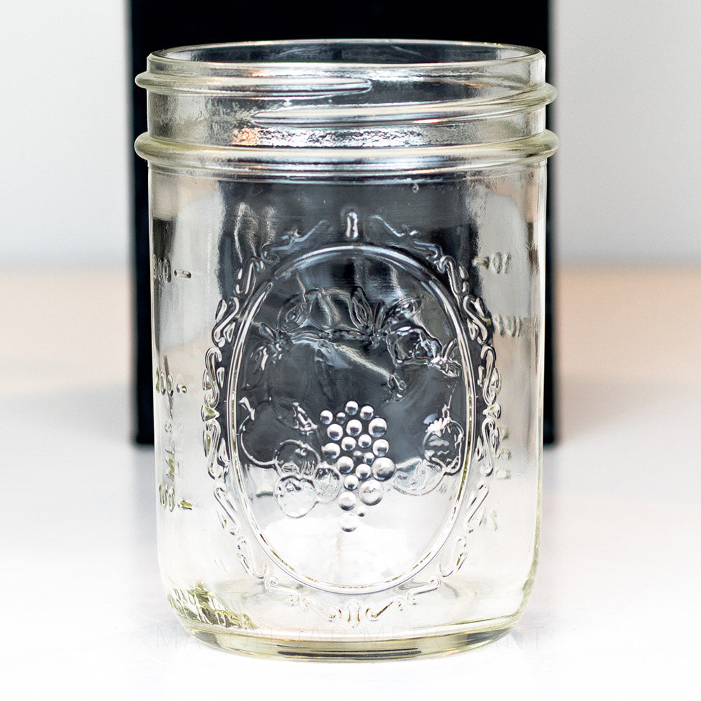 close up of a Ball wide mouth pint mason jar with decorative fruits showing, on a white background