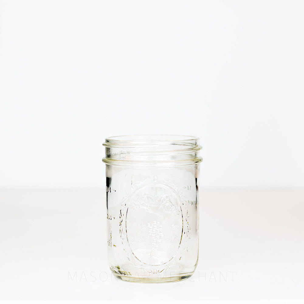 Ball wide mouth pint mason jar with decorative fruits showing, on a white background