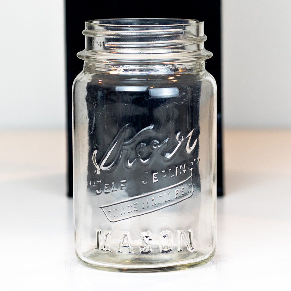 close up of a Vintage regular mouth pint mason jar with Kerr logo, on a white background