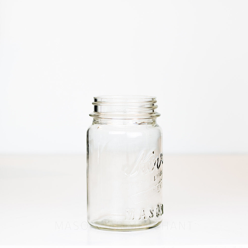 side view of a Vintage regular mouth pint mason jar with Kerr logo, on a white background
