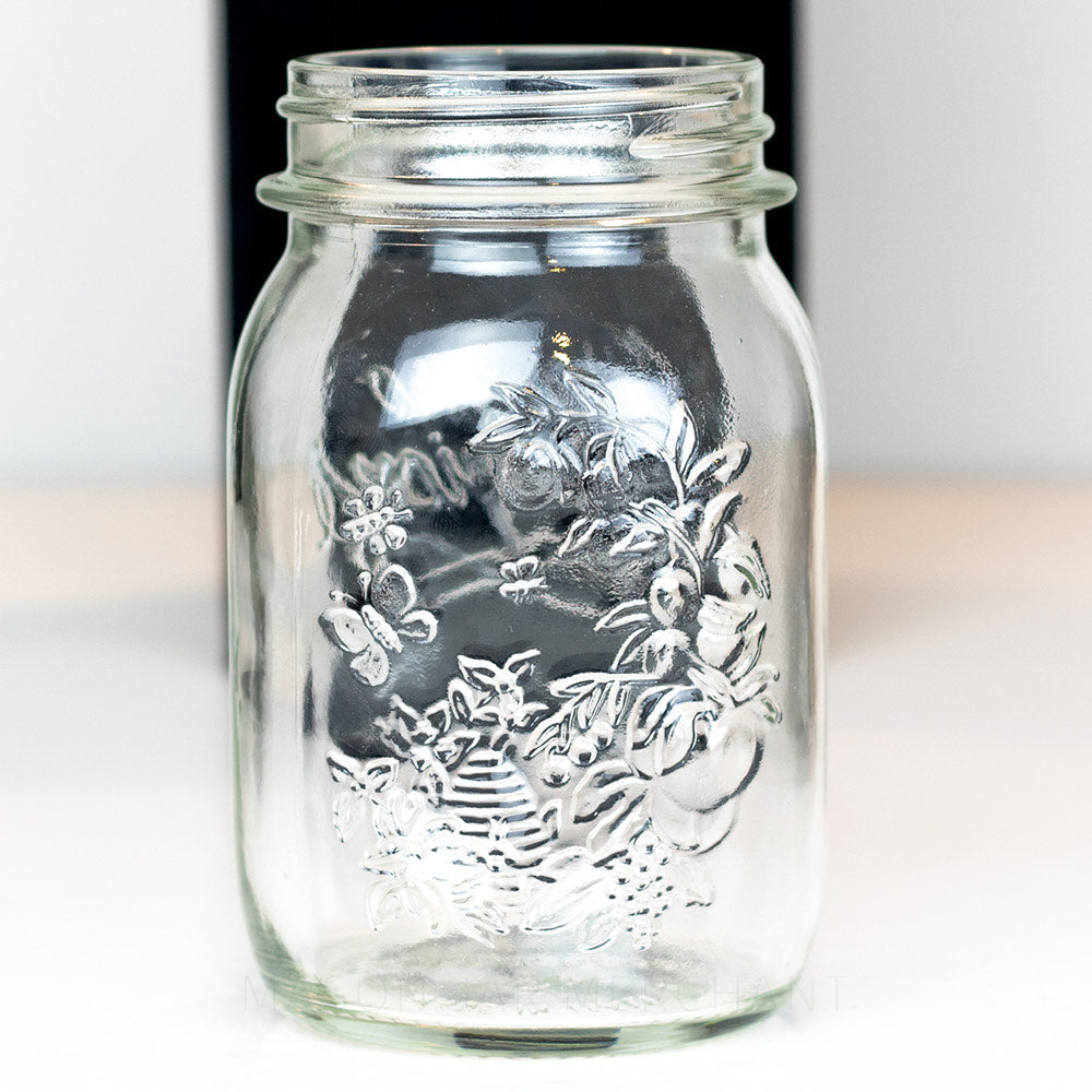 close up of a Regular mouth pint mason jar with Quattro Stagioni logo, on a white background. It has a floral pattern