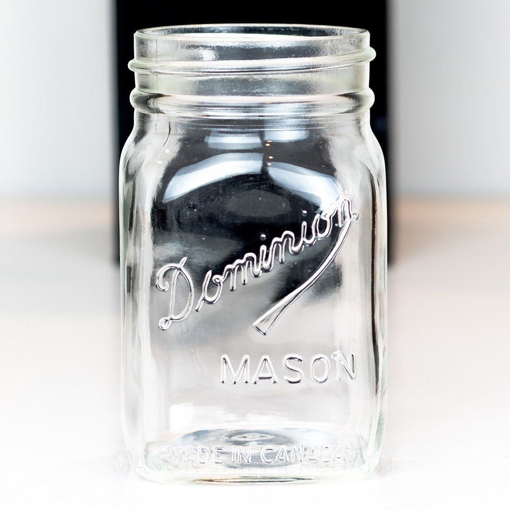close up of a Dominion wide mouth pint mason jar on a white background