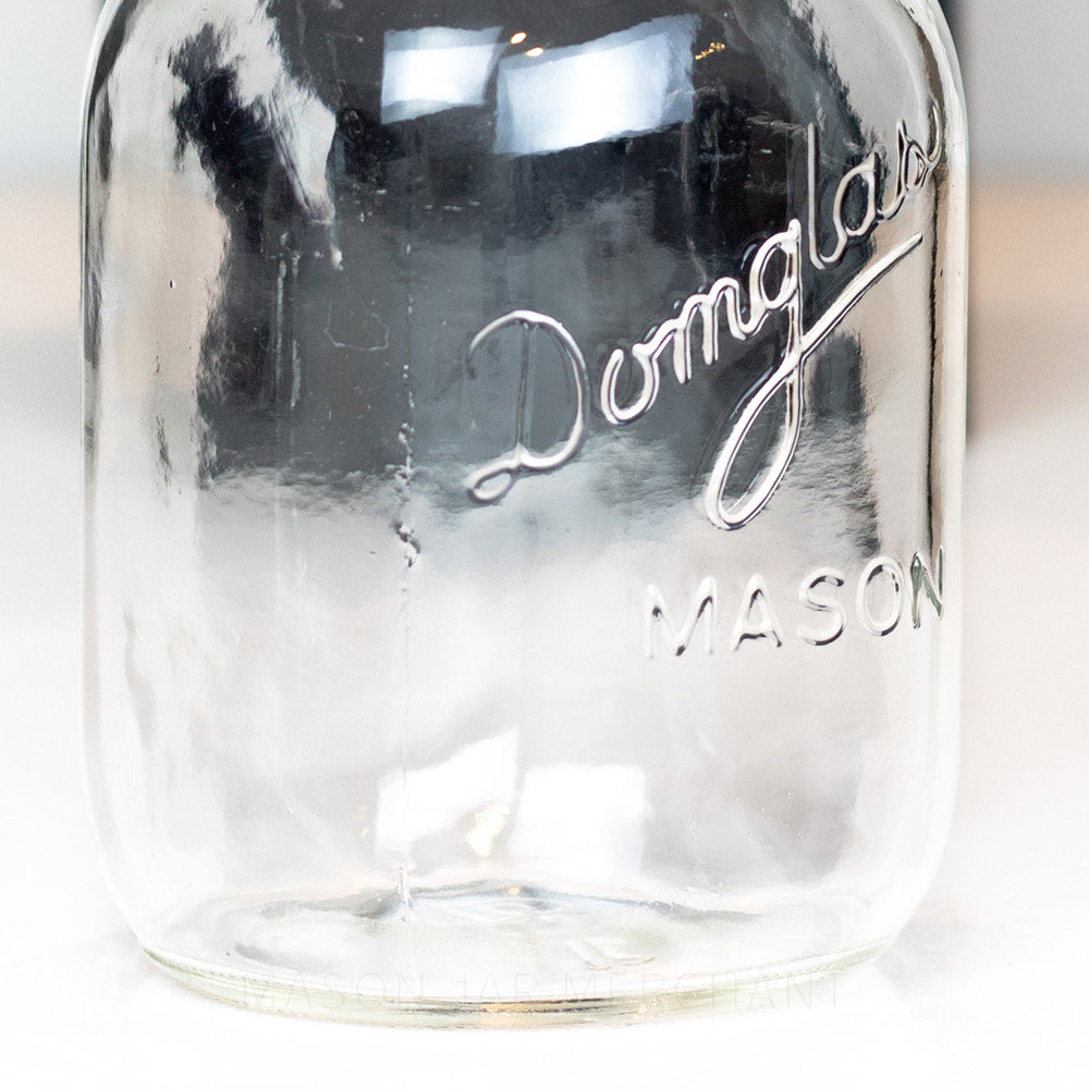 close up of the details of a Regular mouth pint mason jar with Domglas logo on a white background