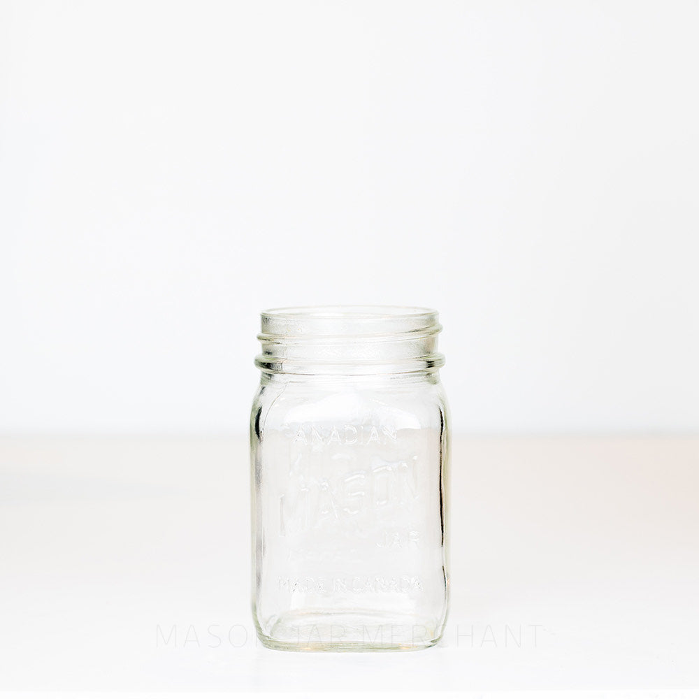 Regular mouth pint mason jar with Canadian Mason Jar, made in Canada logo, on a white background