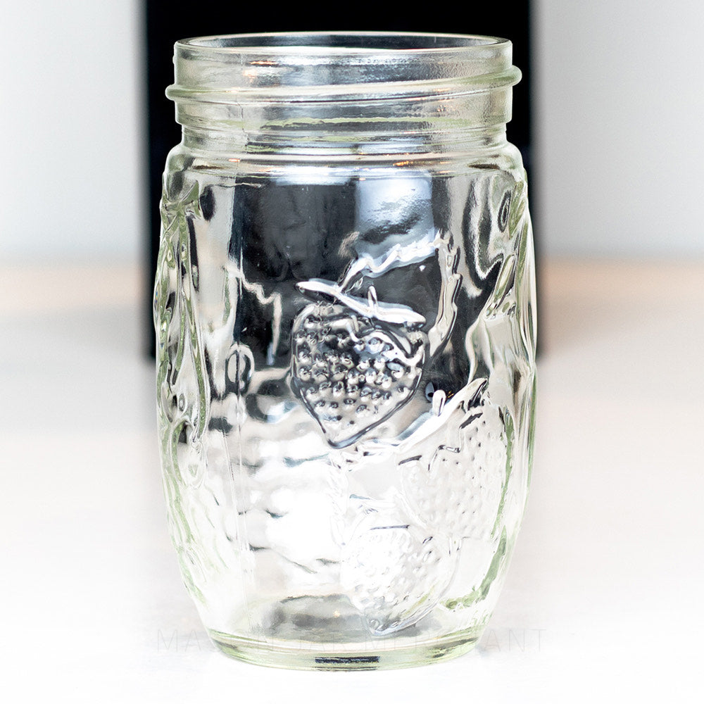 A close up of a 10 oz regular mouth mason jar with a unique tall and thin bulb shape, on a white background