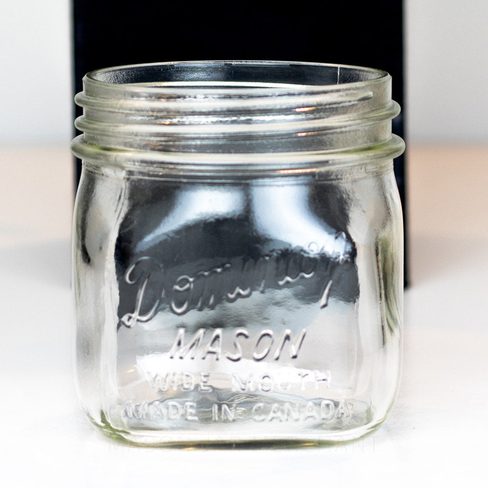 close up of a Dominion wide mouth glass mason jar pint on a white background