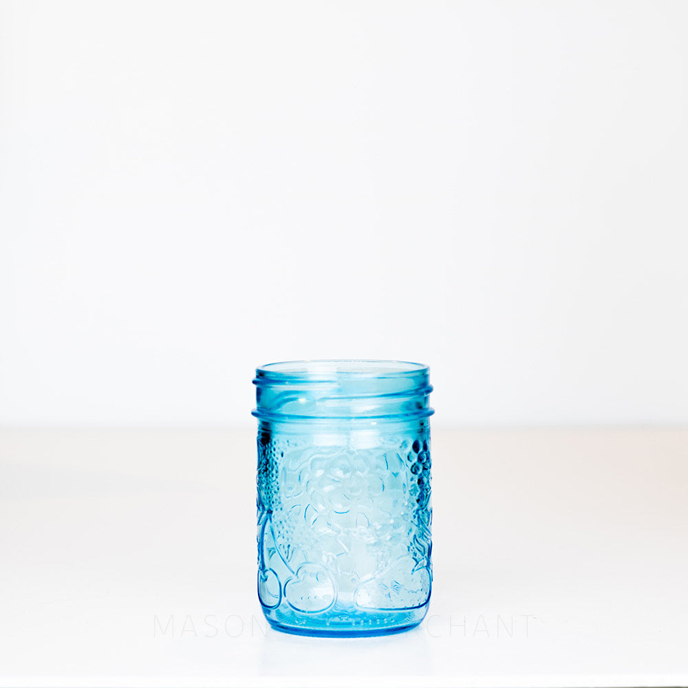 Fruity patterned blue regular mouth half pint mason jar on a white background